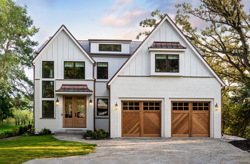 white house with white carriage garage doors