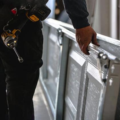 technician replacing garage door panels