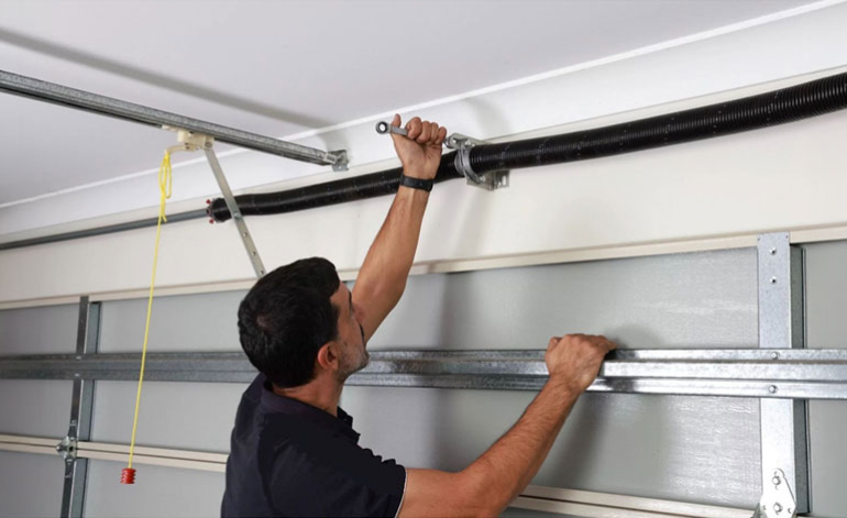 technician performing maintenance on a garage door