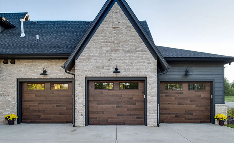 exterior of a gray house with brown wood garage doors
