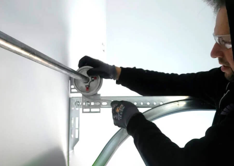 technician winding a garage door cable on its drum