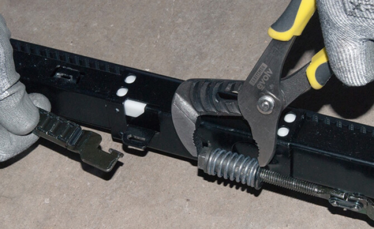 technician repairing a garage door spring