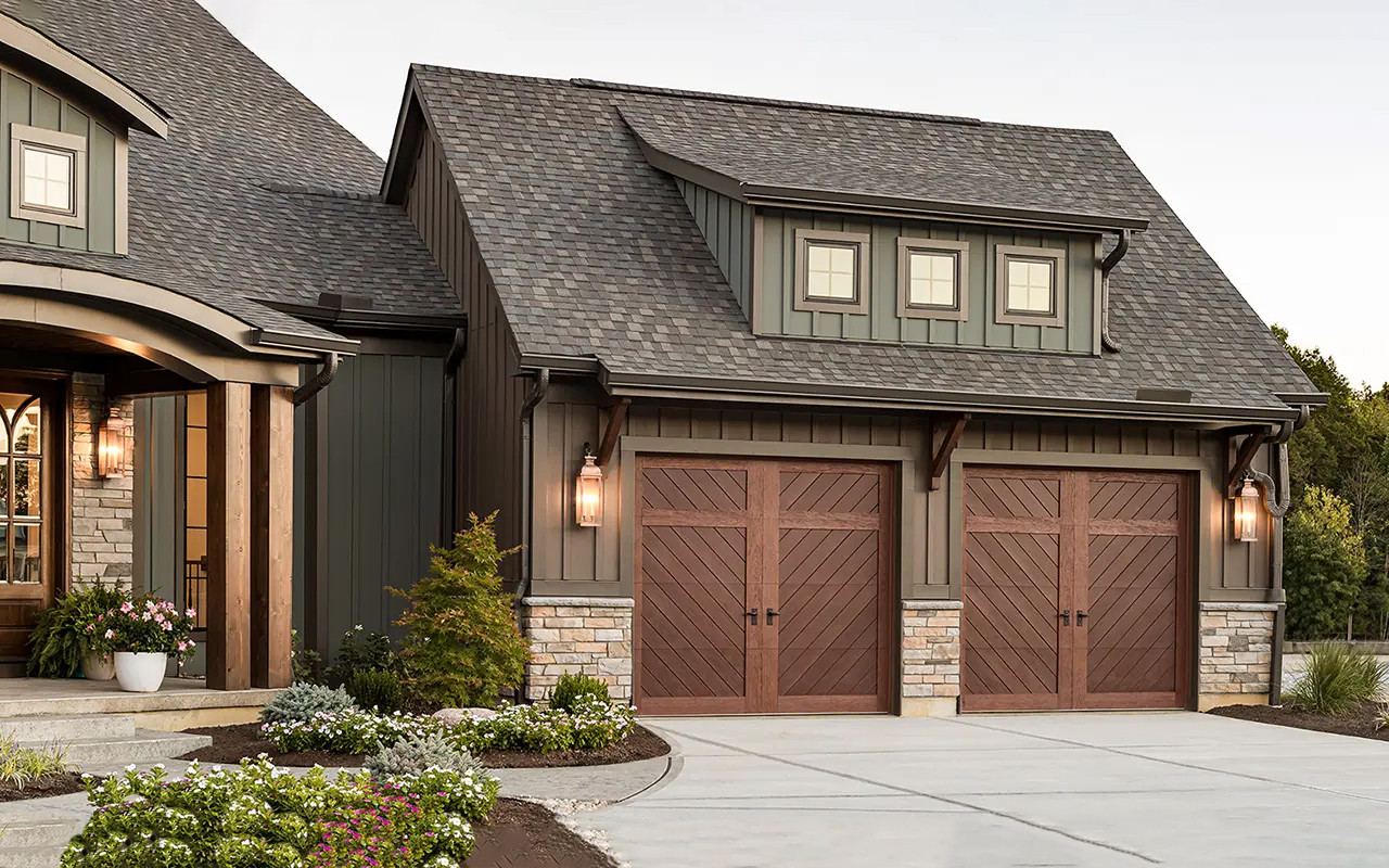 exterior of a green house with brown garage doors