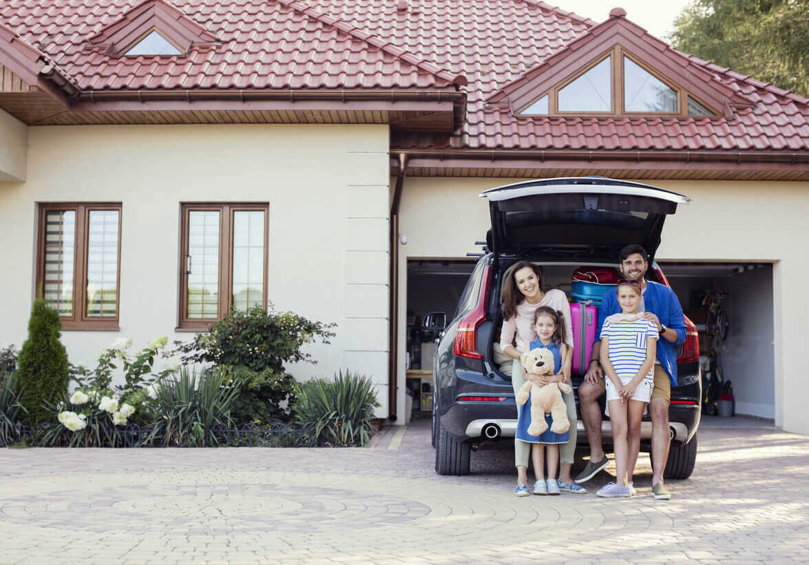 family sitting in front of their garage