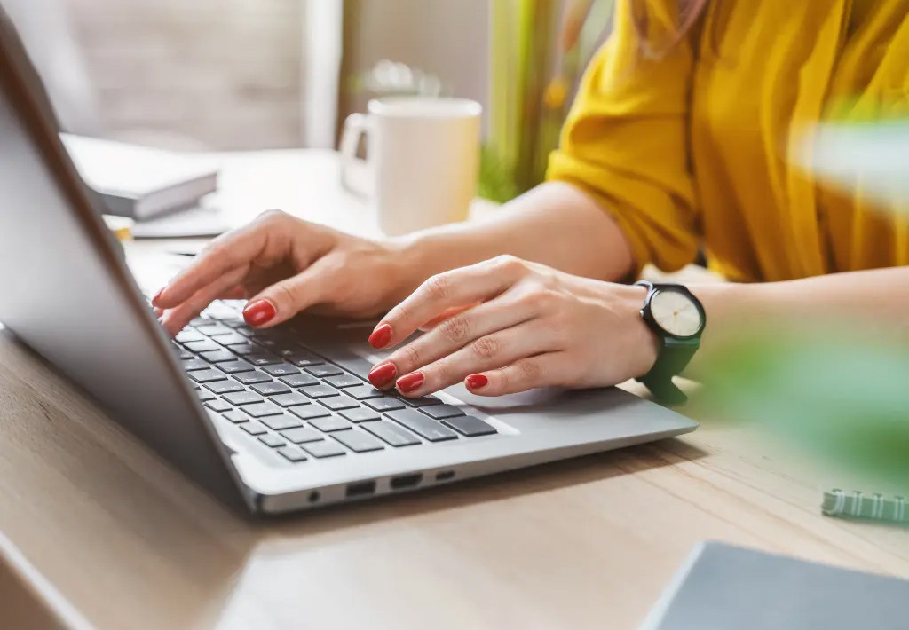 woman's hands at a computer keyboard