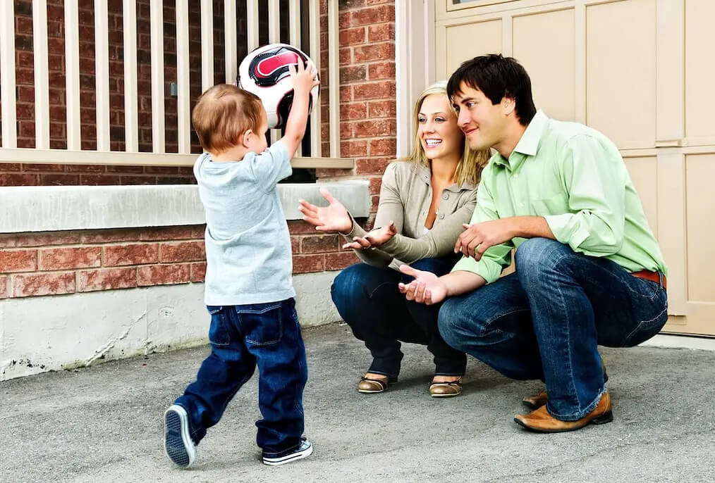 family playing with a ball on a driveway