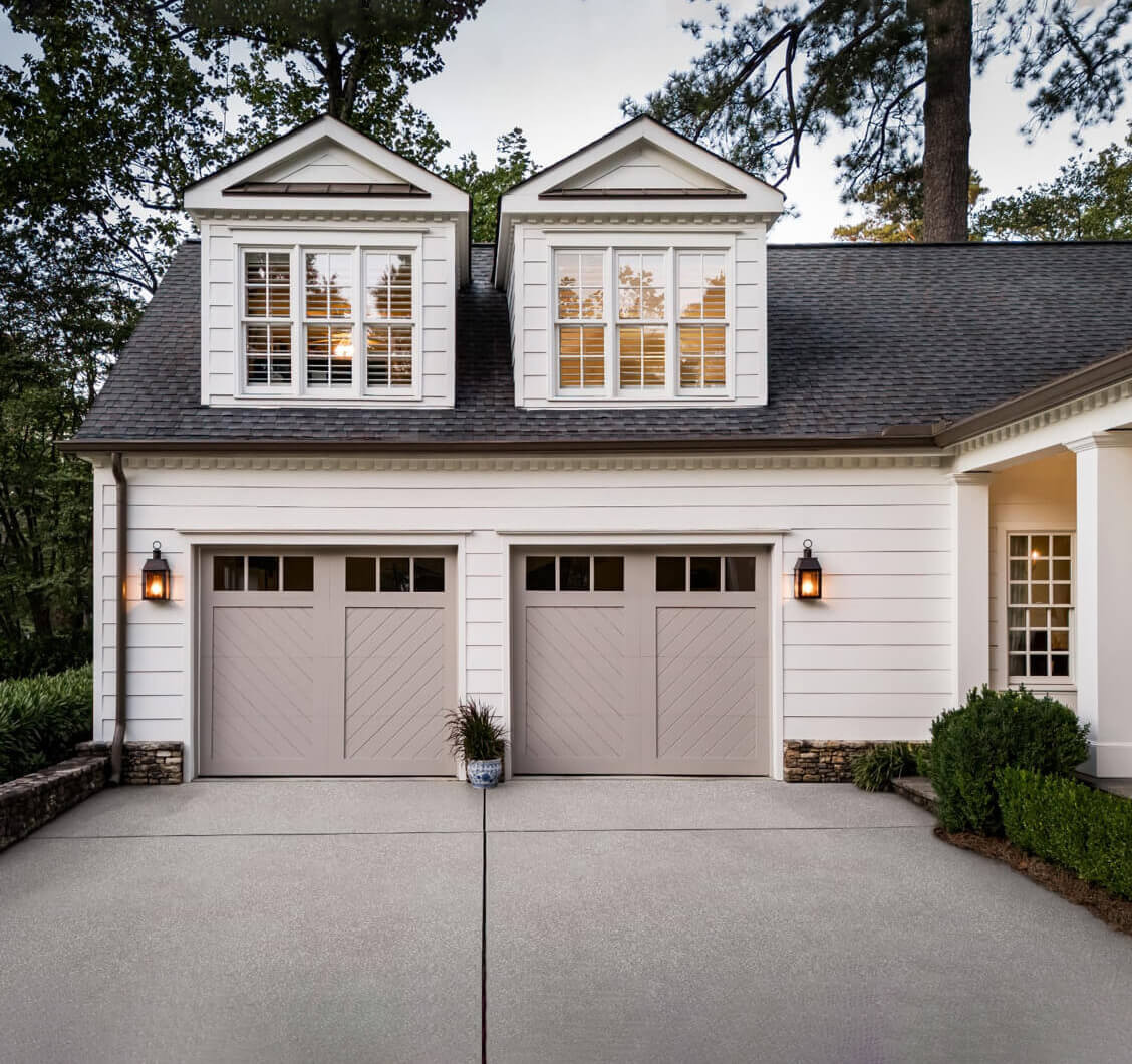 exterior of a white house with light brown garage doors