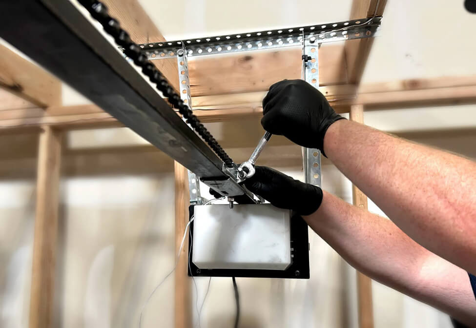 technician working on the chain of a garage door opener