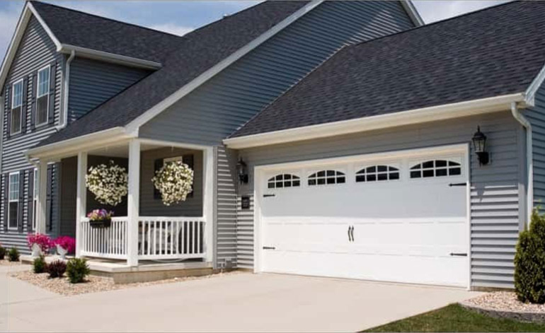 exterior of a gray house with white garage doors
