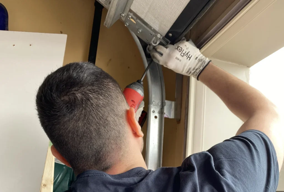 technician working on a garage door track
