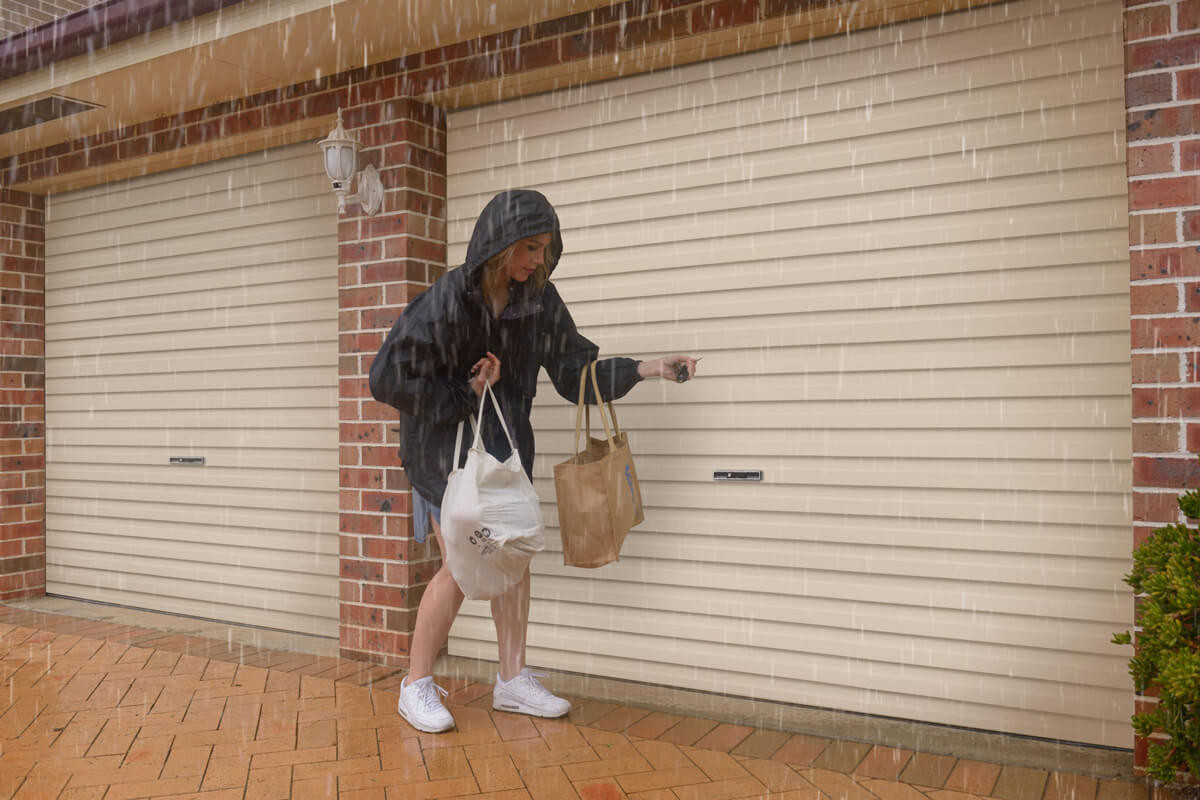 woman opening a garage door in the rain
