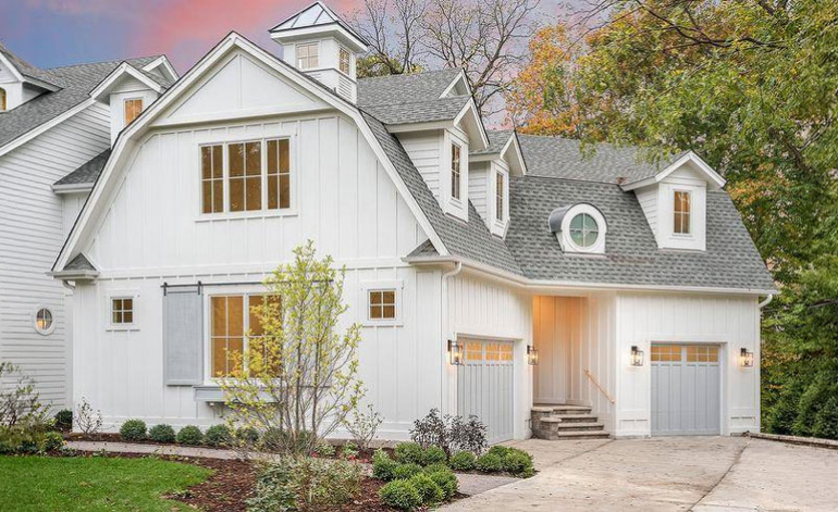 exterior of a white house with light gray garage doors